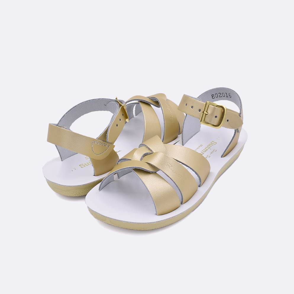 Two little kid sized 8000 Swimmer style sandals with gold straps and white insoles. Both pushed together facing the camera diagonally.