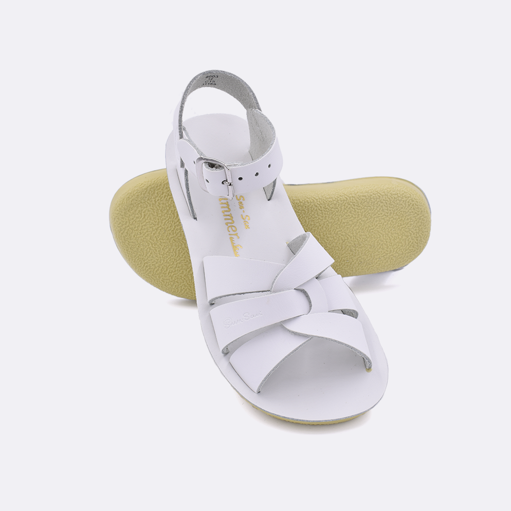 Two little kid sized 8000 Swimmer style sandals with white straps and white insoles.  One standing with the sole facing the camera. The second is laying diagonally over the top left edge of the sole.