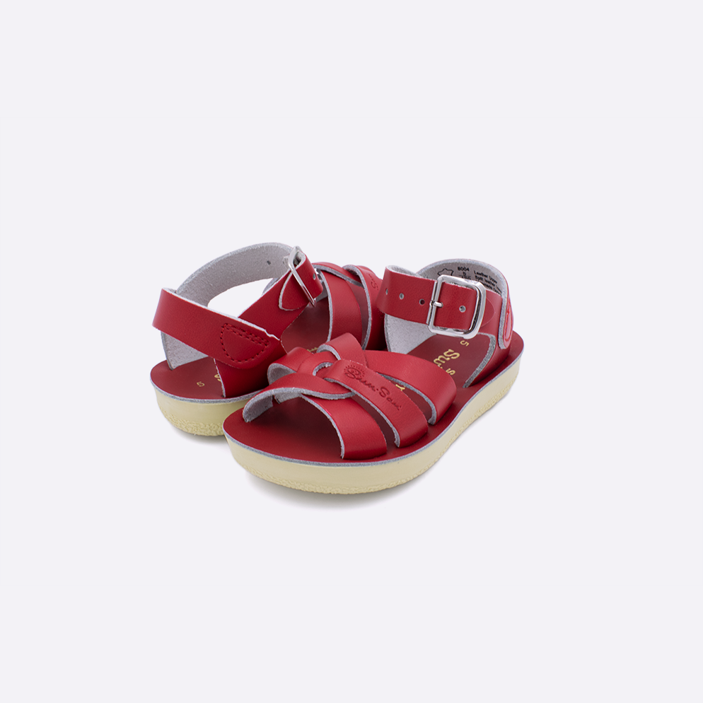 Two toddler sized 8000 Swimmer style sandals with red straps and red insoles. Both pushed together facing the camera diagonally.