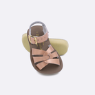 Two toddler sized 8000 Swimmer style sandals with rose gold straps and beige insoles.  One standing with the sole facing the camera. The second is laying diagonally over the top left edge of the sole.