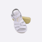 Two toddler sized 8000 Swimmer style sandals with white straps and white insoles.  One standing with the sole facing the camera. The second is laying diagonally over the top left edge of the sole.
