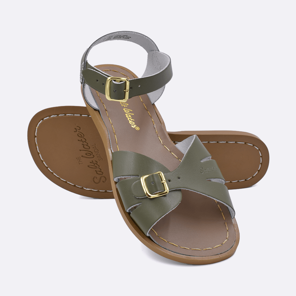Two 900 Classic style sandals color olive.  One standing with the sole facing the camera. The second is laying diagonally over the top left edge of the sole.	Adult Size.