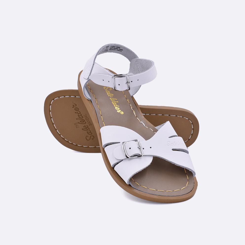 Two 900 Classic style sandals color white.  One standing with the sole facing the camera. The second is laying diagonally over the top left edge of the sole.	Little Kid Size.