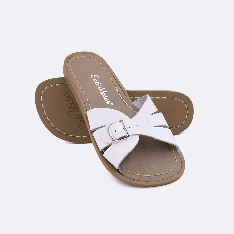 Two 9900 Classic Slide style sandals color white.  One standing with the sole facing the camera. The second is laying diagonally over the top left edge of the sole.	Little Kid Size.